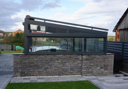 Jihlava Samostojná pergola Rapallo s prosklenou střechou, rozměr 6000x4000mm, barva konstrukce Antracit RAL 7016 s jemnou strukturou.Doplňky :Zasklení bezrámové zasklení SimpleLine VIEWBoční rolety TARA PREMIOStřešní markýza MILLENIUM II